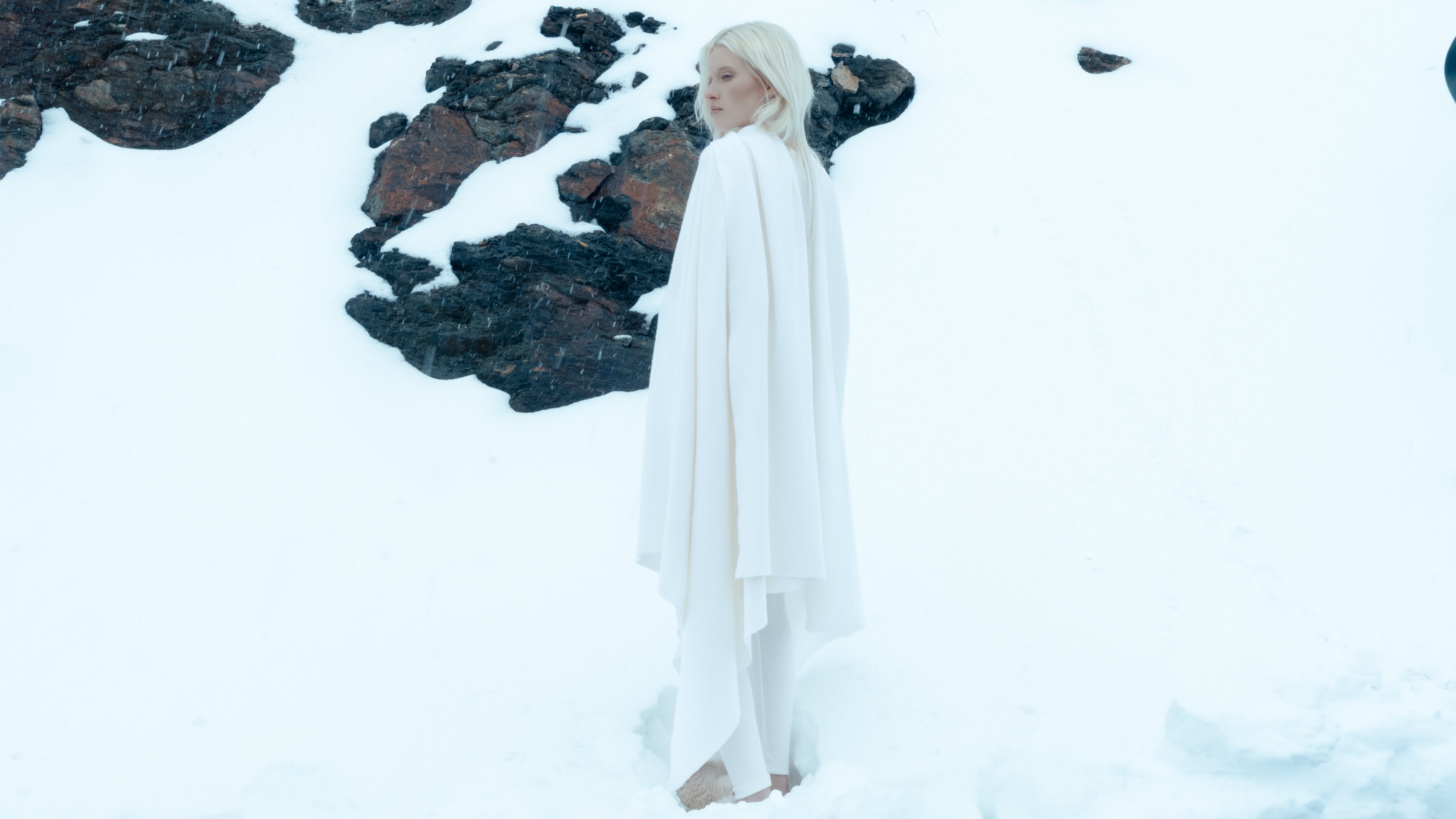 Woman standing with wool throw over shoulder in a snowy landscape