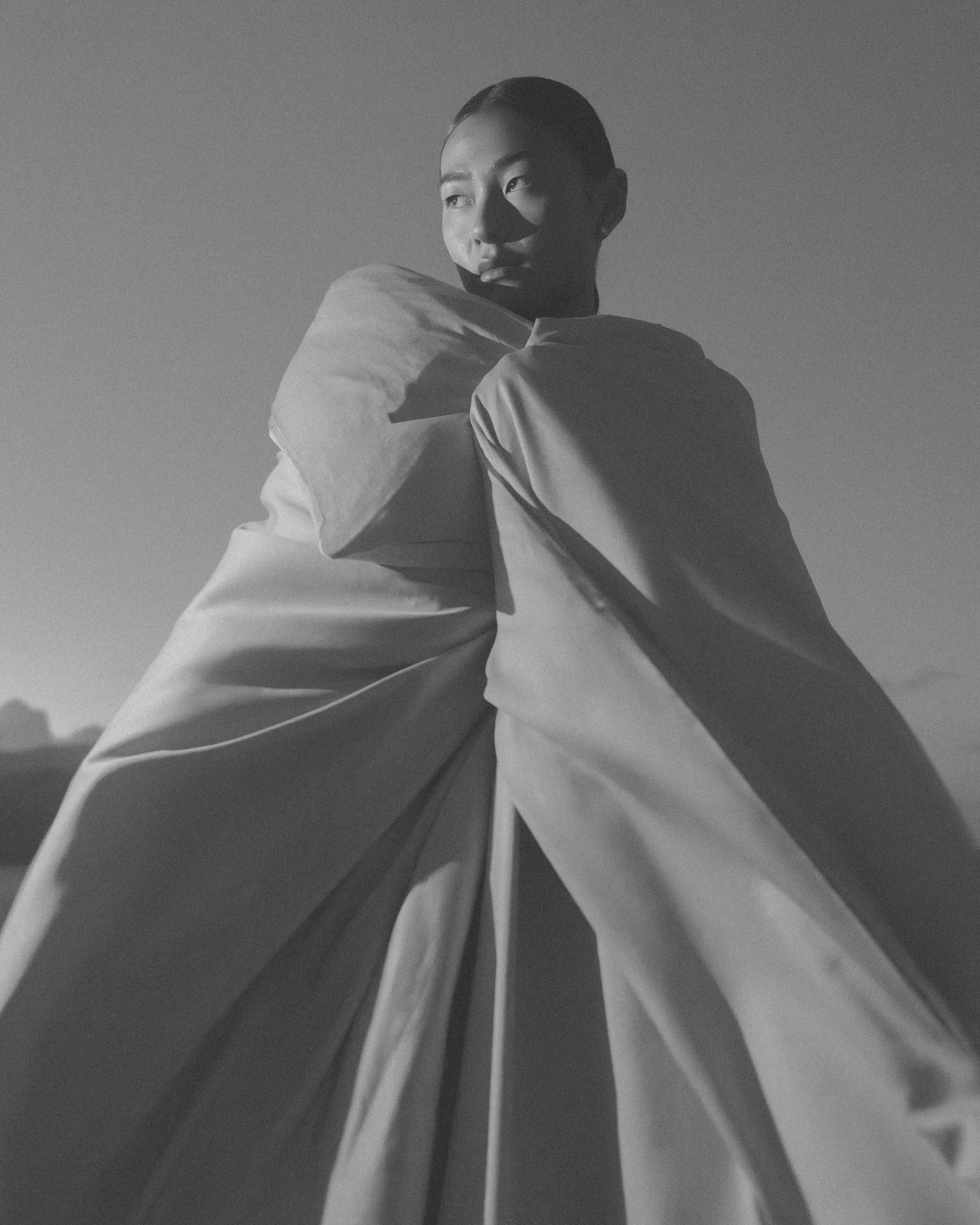 woman wrapped in a big soft duvet in a black and white image