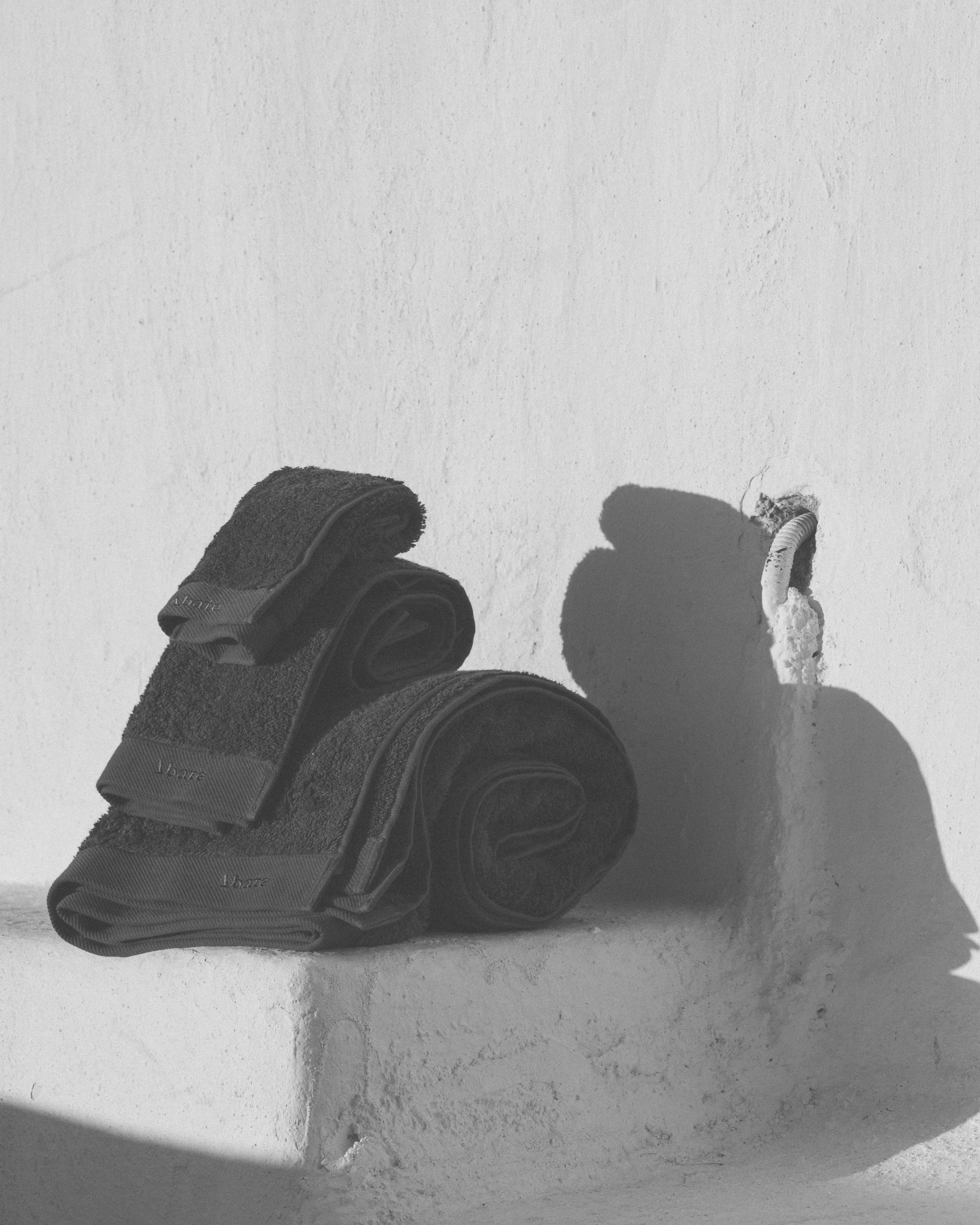 Dark grey towels stacked on each other in a black and white photo